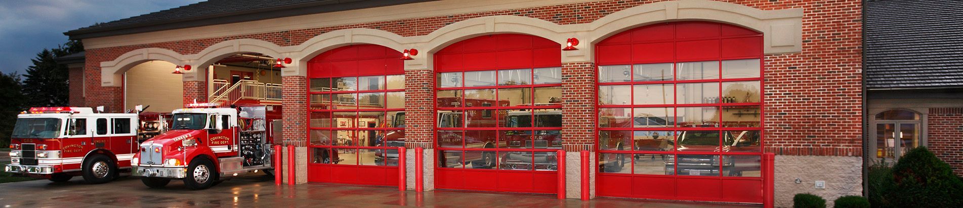 A fire truck is parked in front of a fire station.