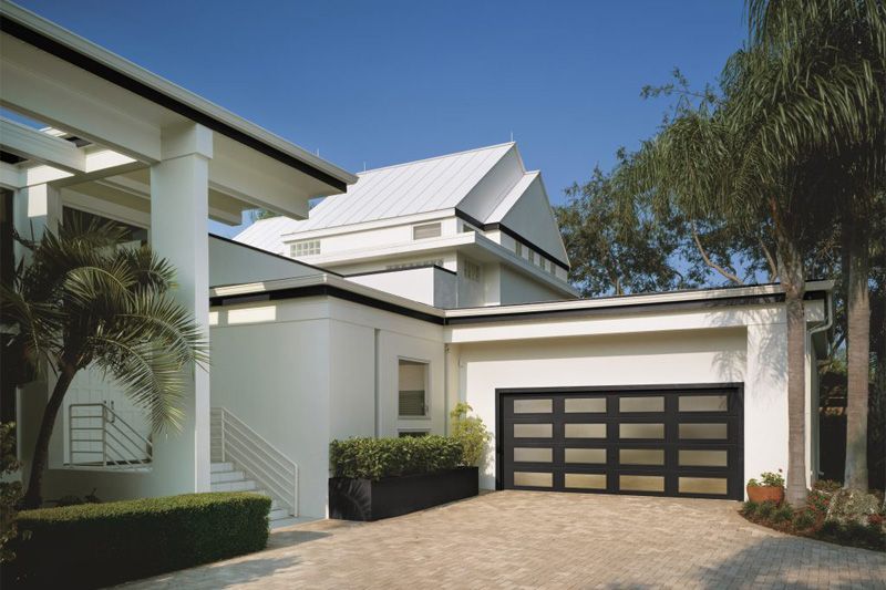 A large white house with a black garage door