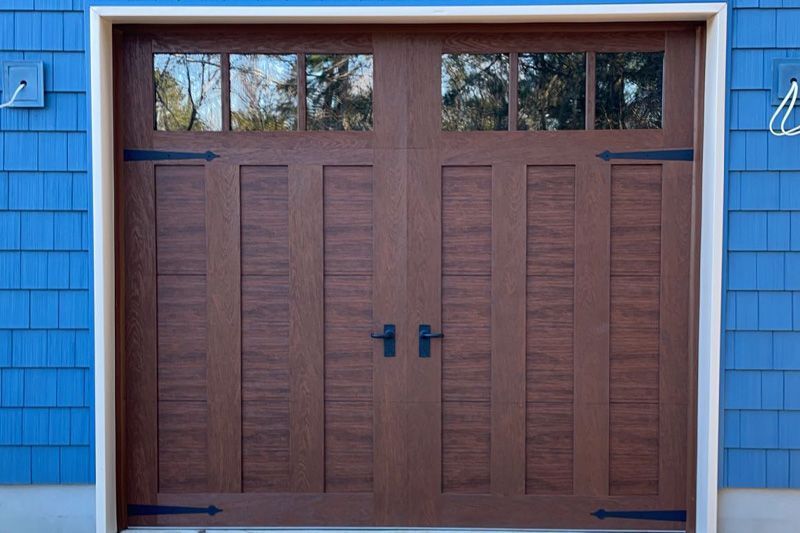 A brown garage door is on a blue house