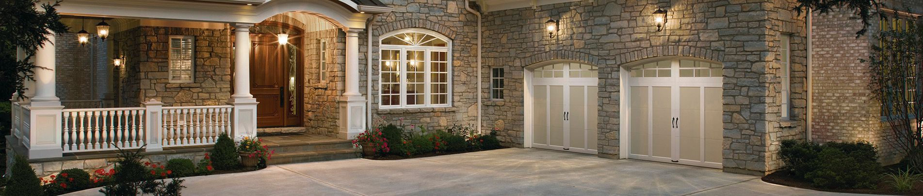 A large stone house with a large driveway leading to it.