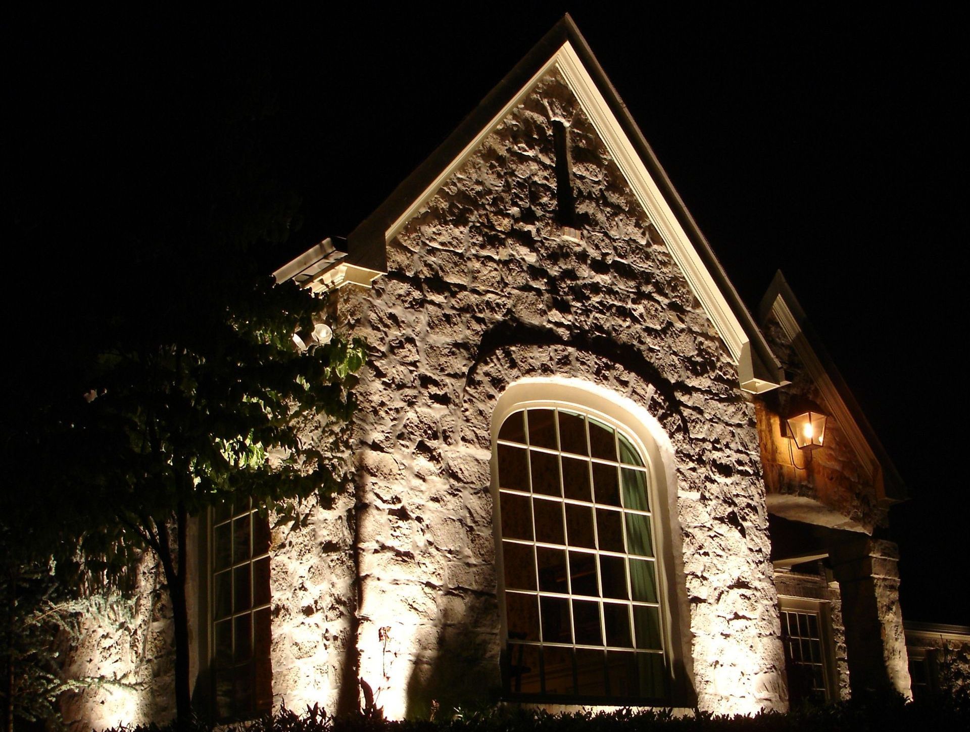 A large stone building is lit up at night