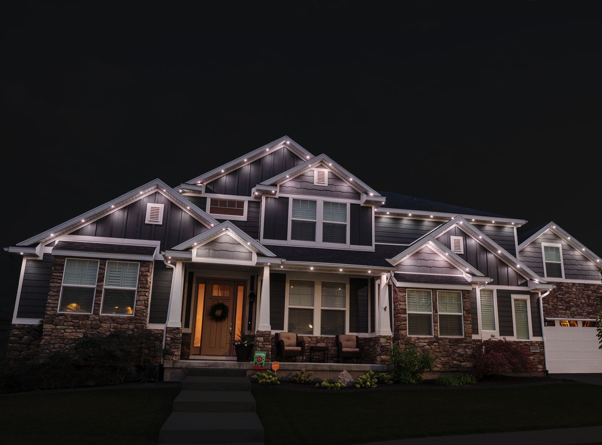 A large house is lit up at night with christmas lights.