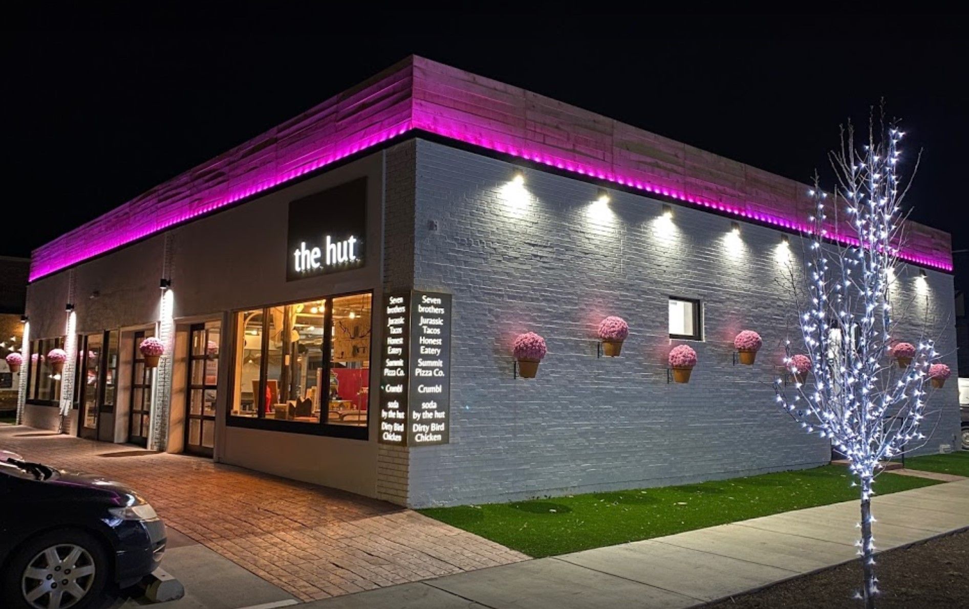 A white building with purple lights on the side of it.