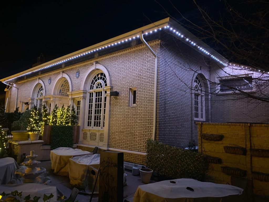 A large brick building with lights on the roof is lit up at night.