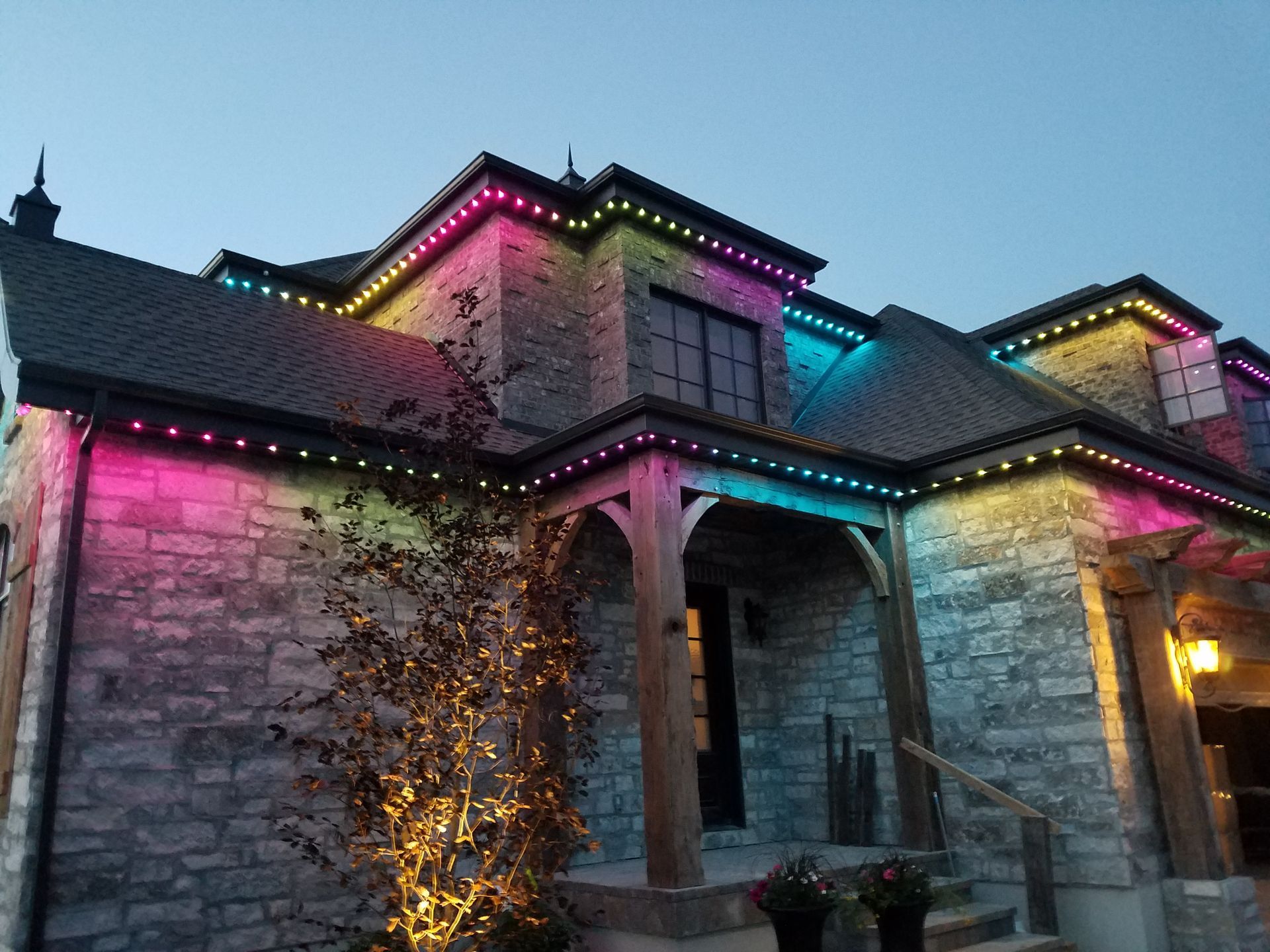 A large brick house with christmas lights on the side of it.