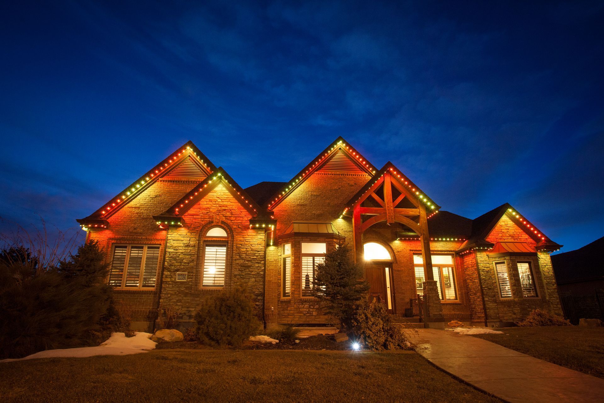 A large house is lit up with christmas lights at night.