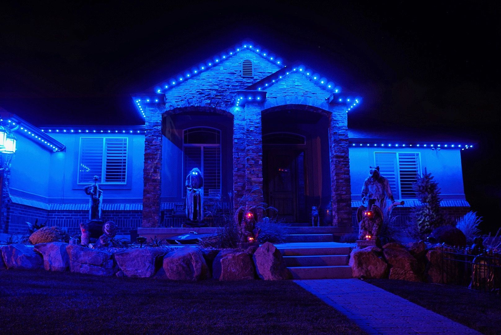 A house is lit up with blue lights for halloween.