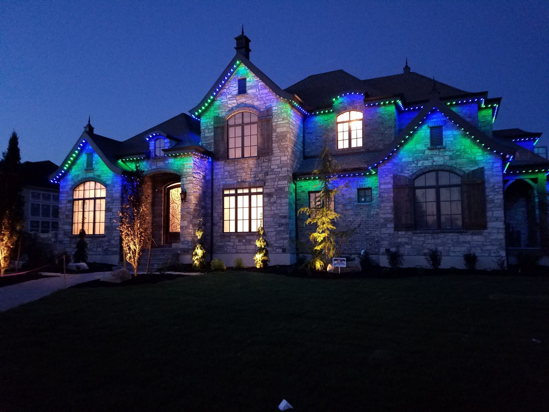 A large house with christmas lights on it at night