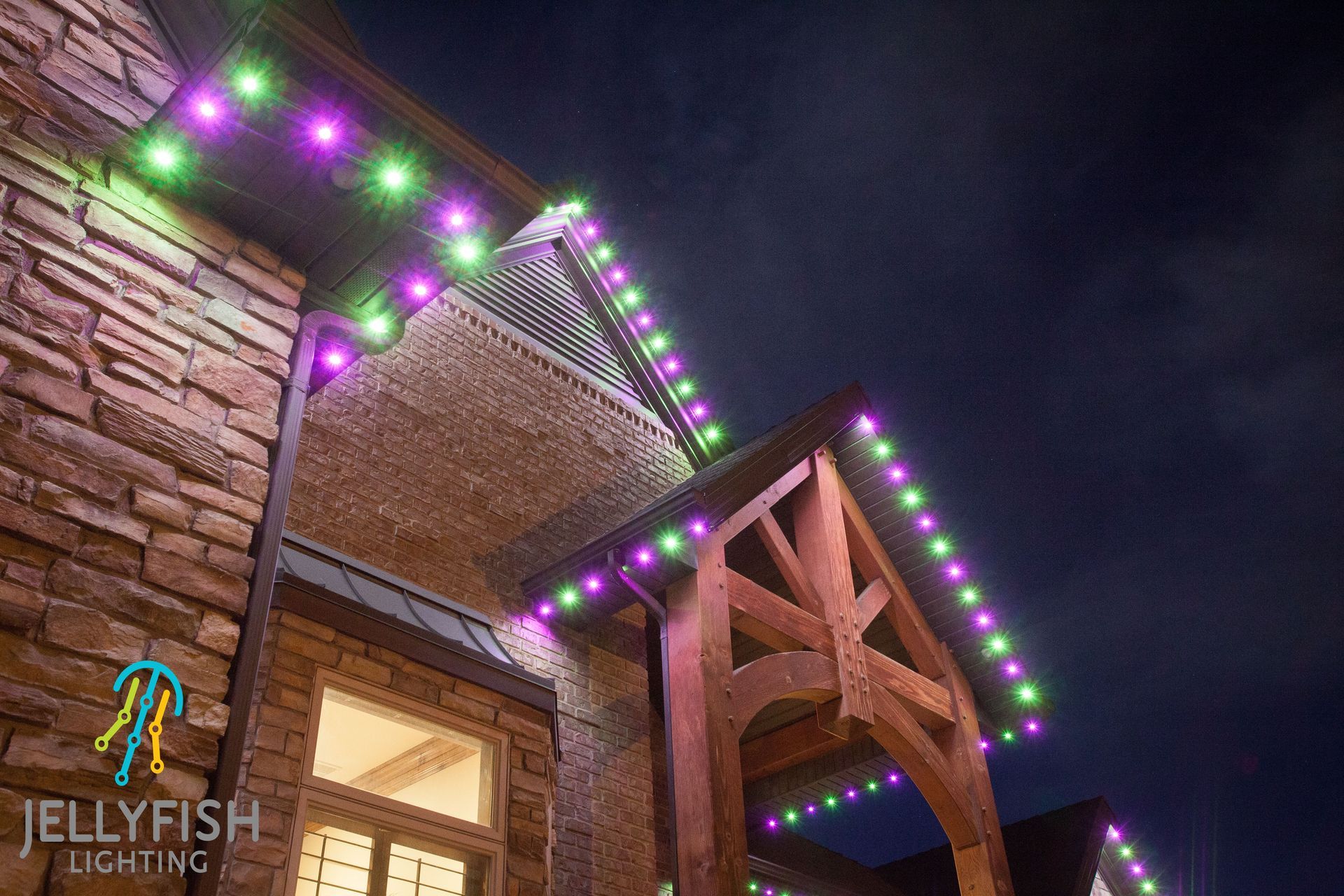 A house with christmas lights on the roof at night.