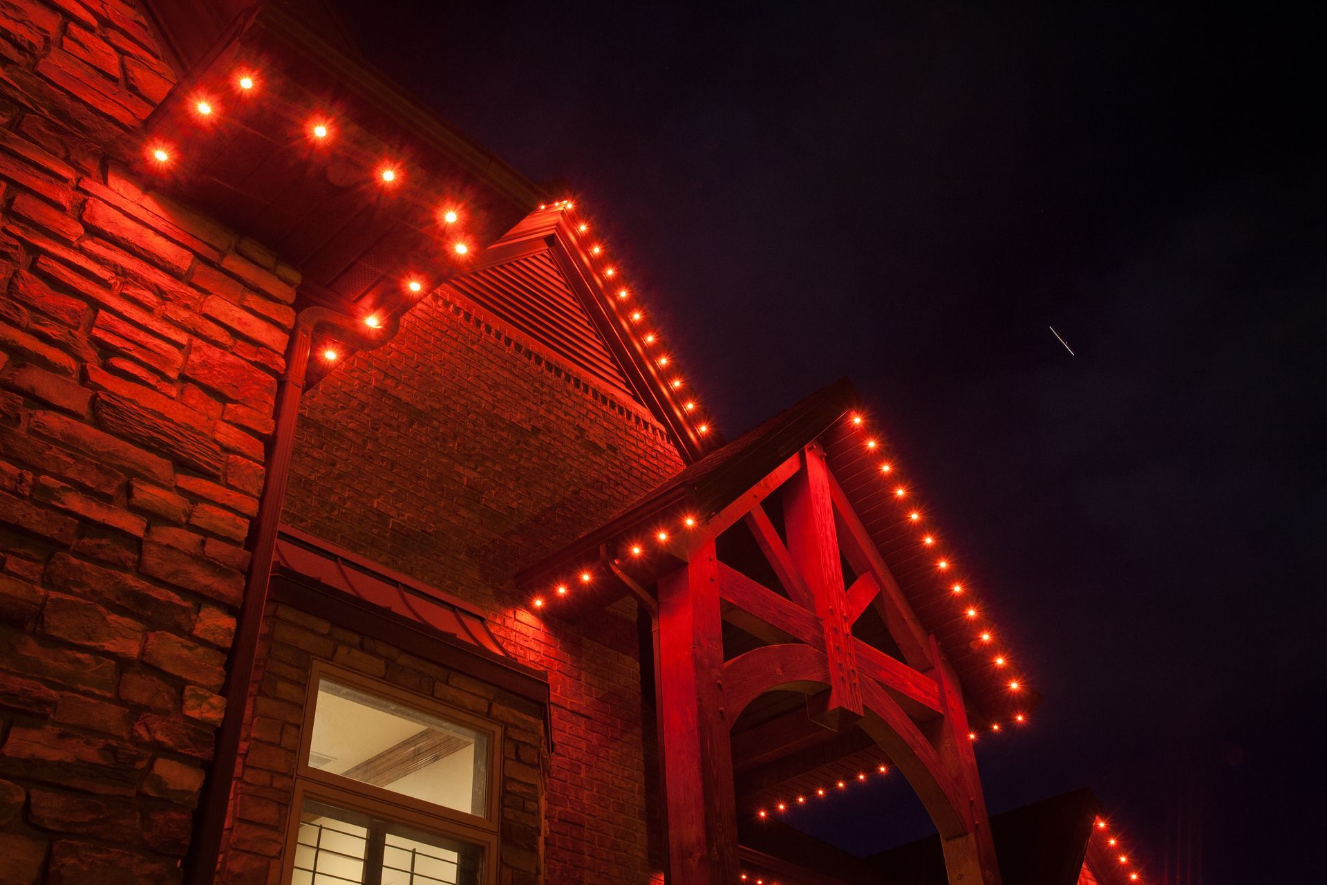 A brick building with red lights on it at night.