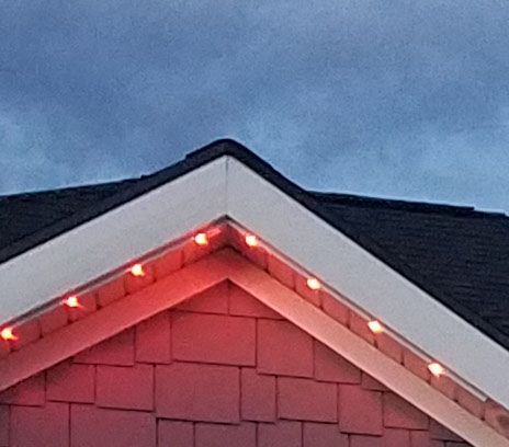 The roof of a house with red lights on it.