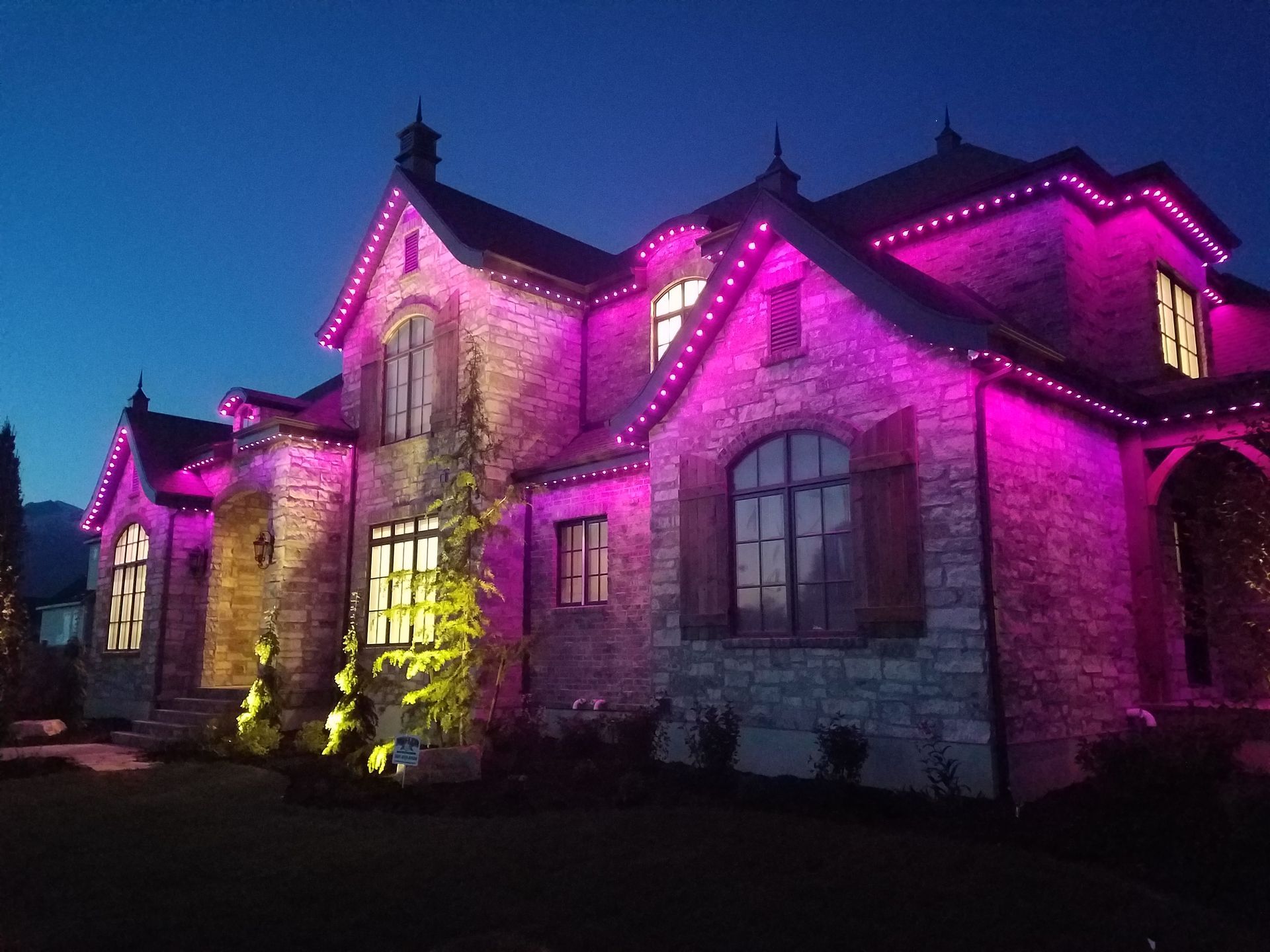 A large house with purple lights on it at night