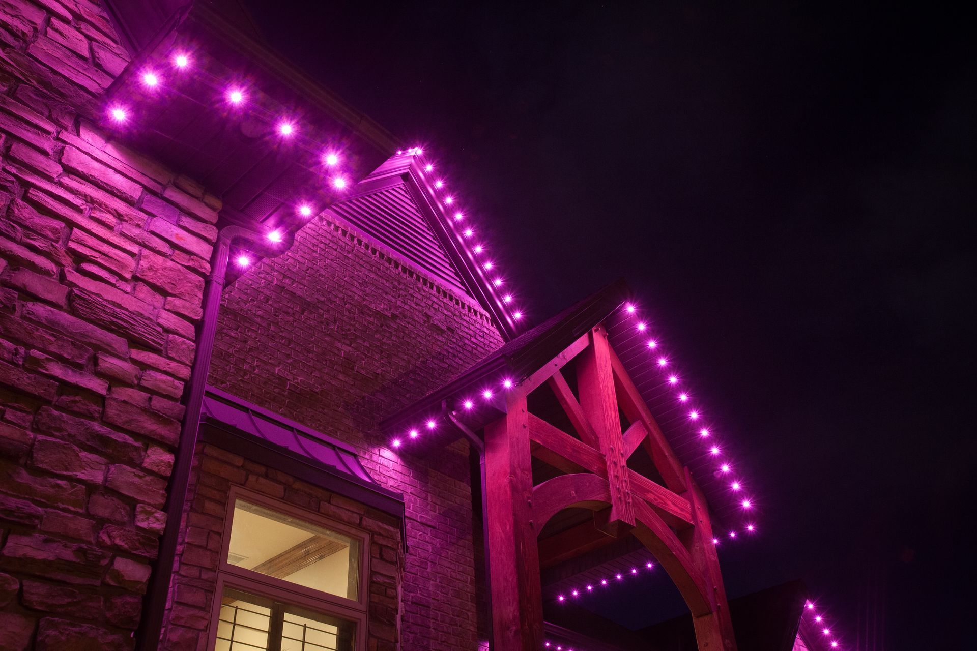 A brick building with purple lights on it at night.