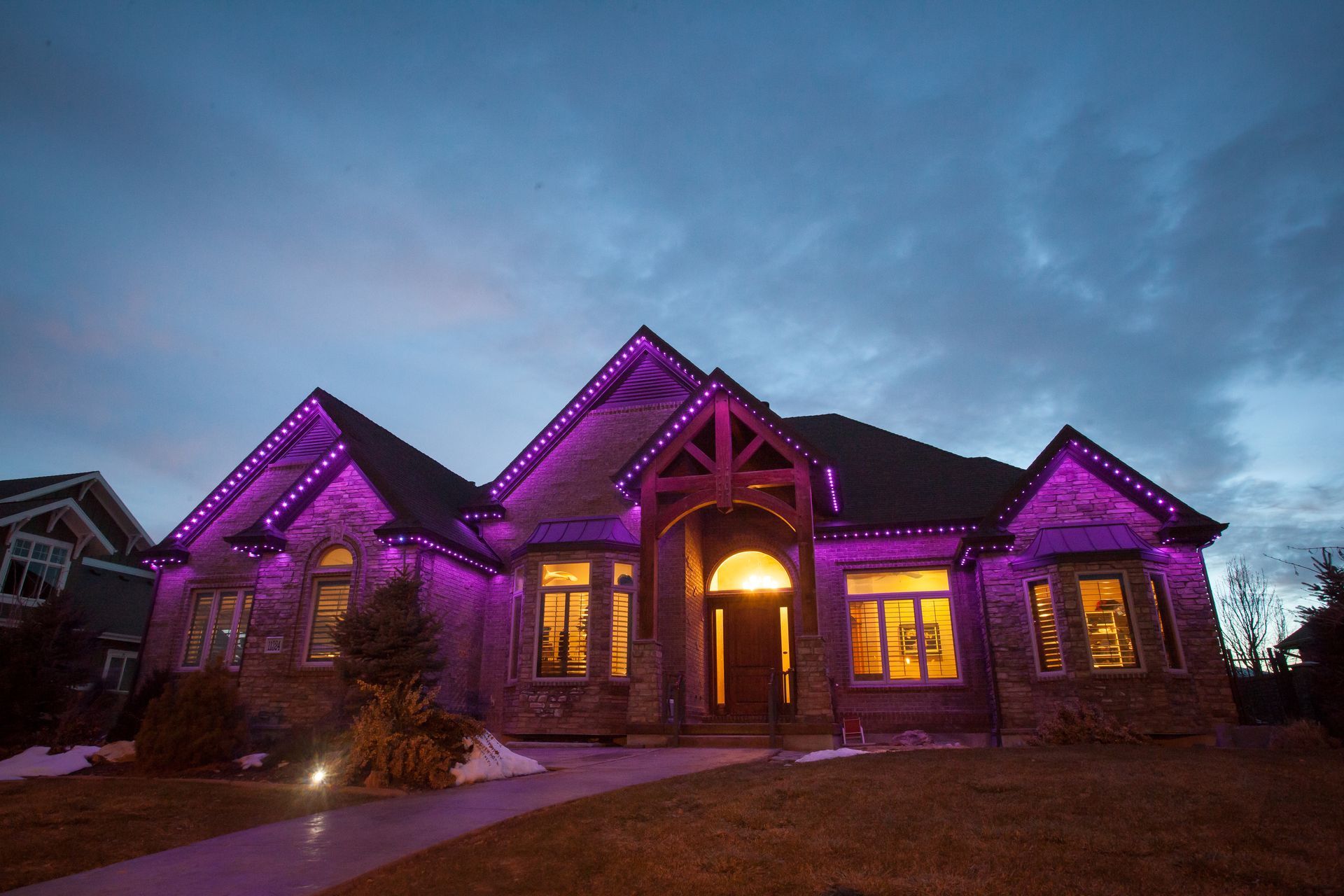 A large house is lit up with purple lights at night.