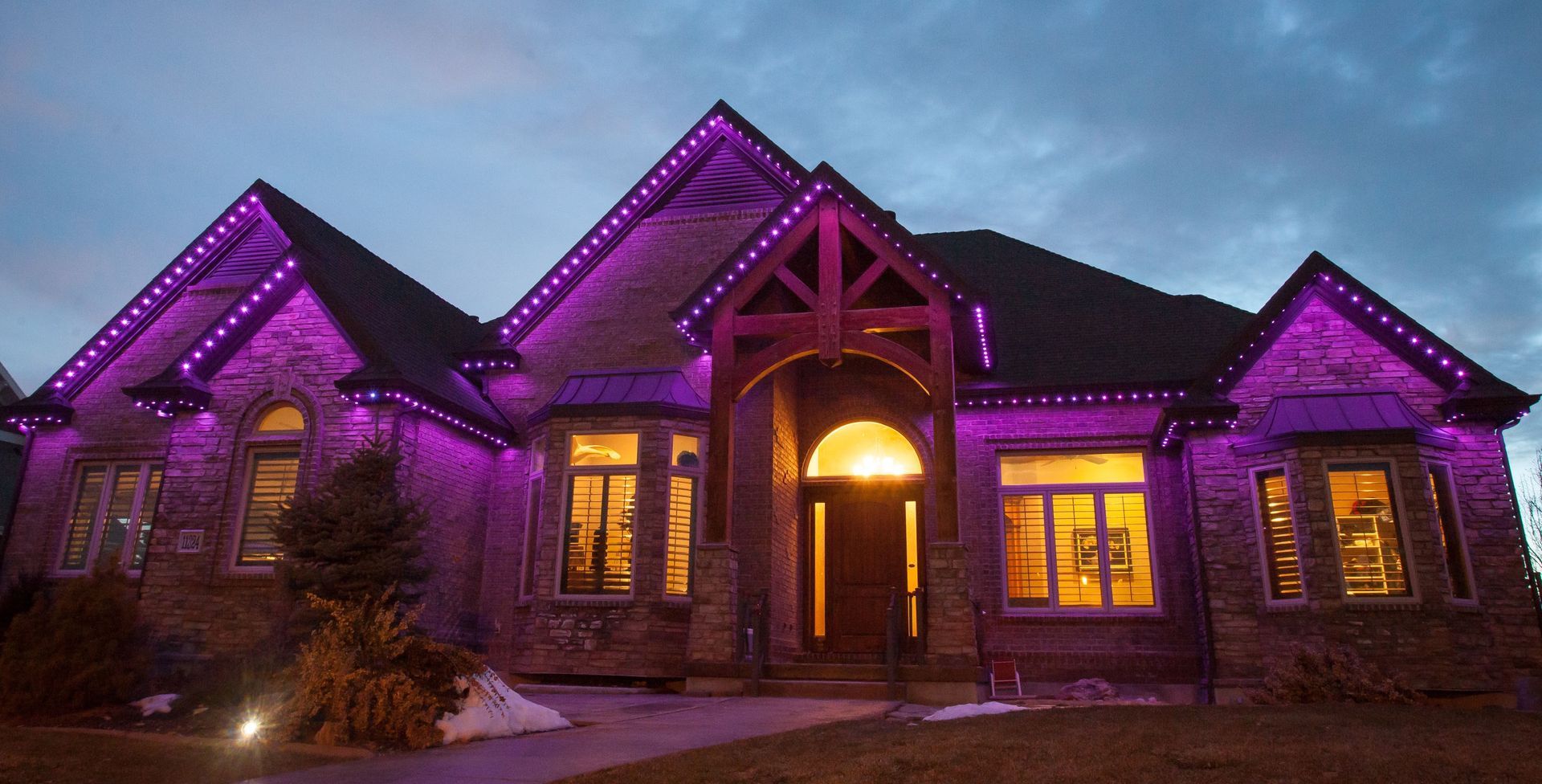 A large house is lit up with purple lights at night.