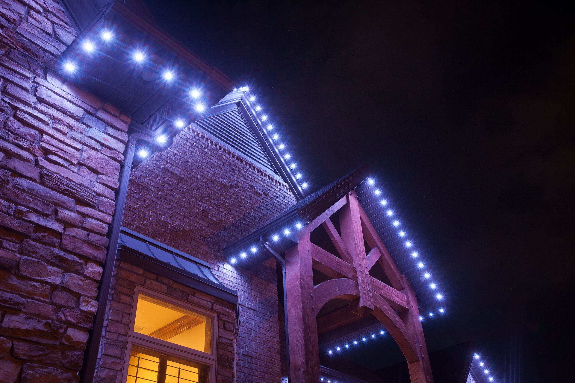 A brick building with purple lights on it at night.