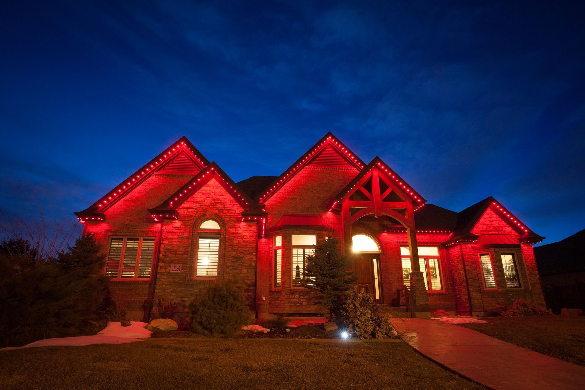 A large house is lit up with red lights at night.
