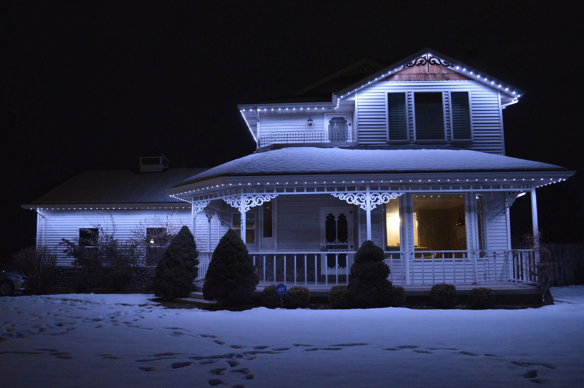 A house with christmas lights on it is lit up at night