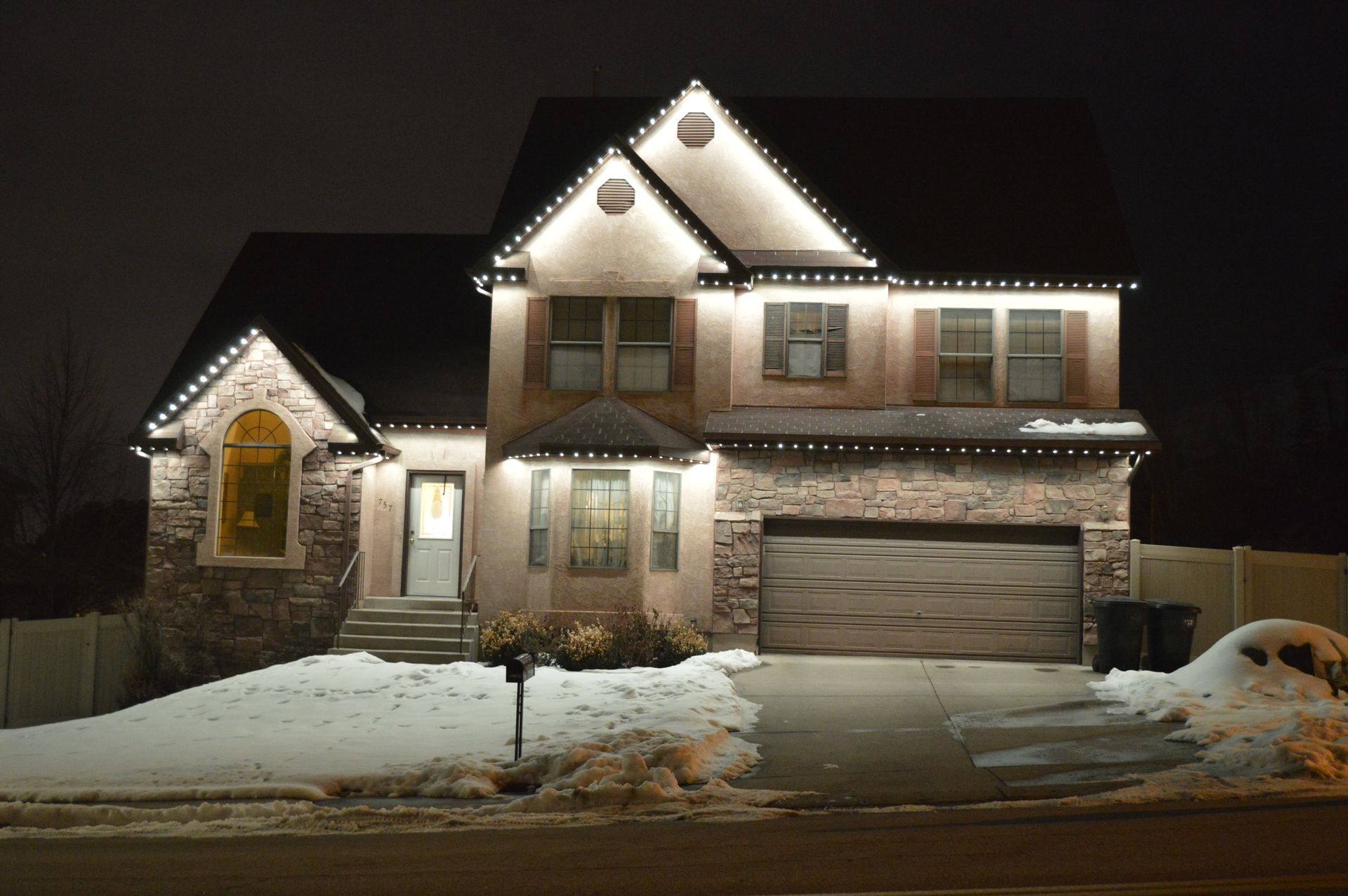 A house with christmas lights on it is lit up at night