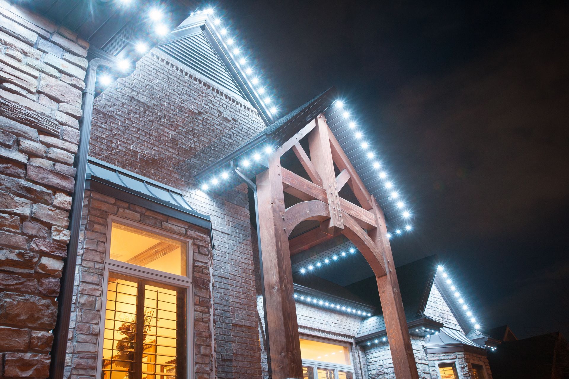A brick building with christmas lights on it at night.