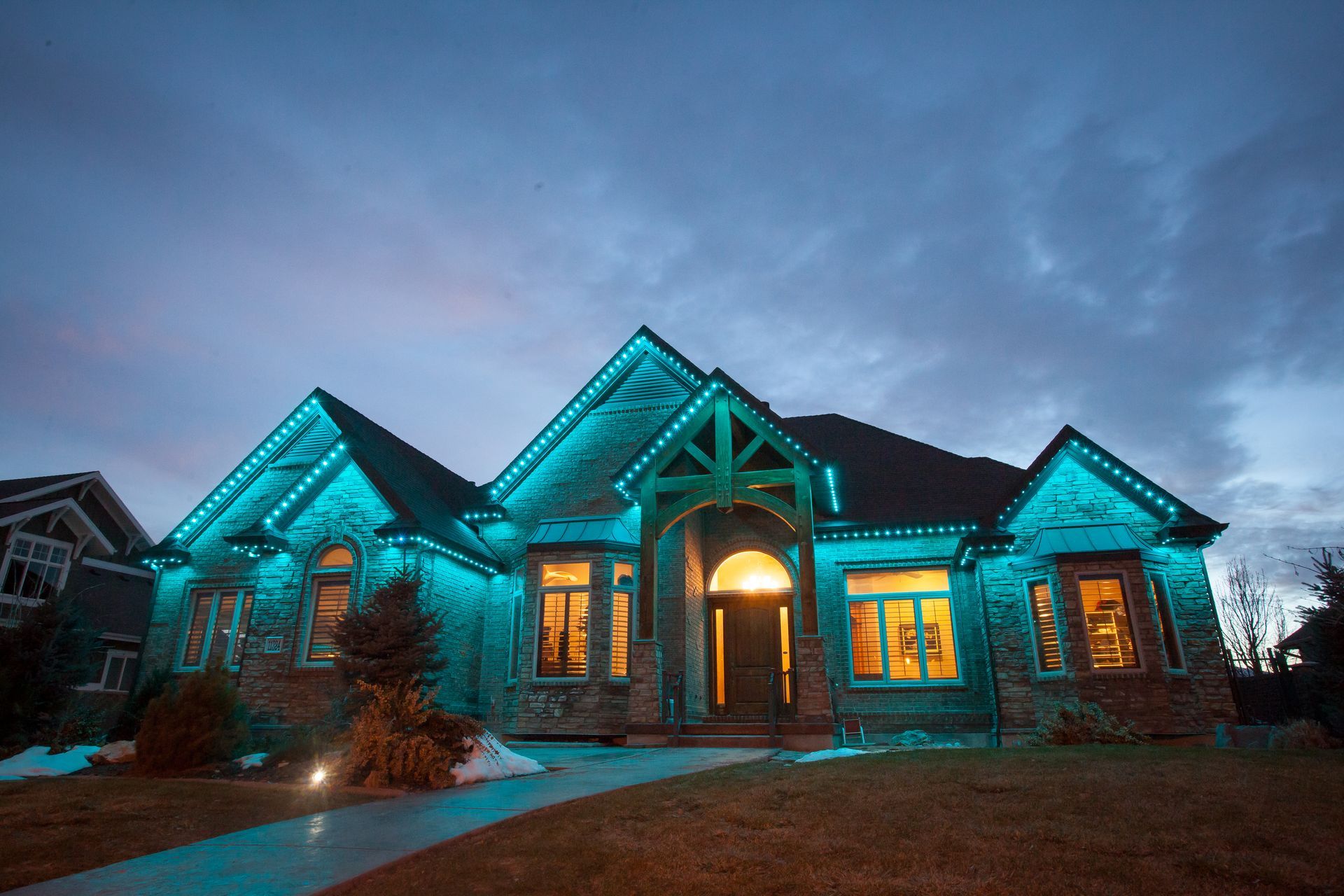 A large house is lit up with blue lights at night.