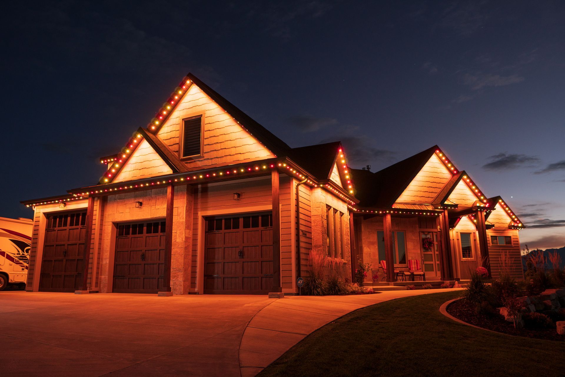 A large house is lit up with christmas lights at night.