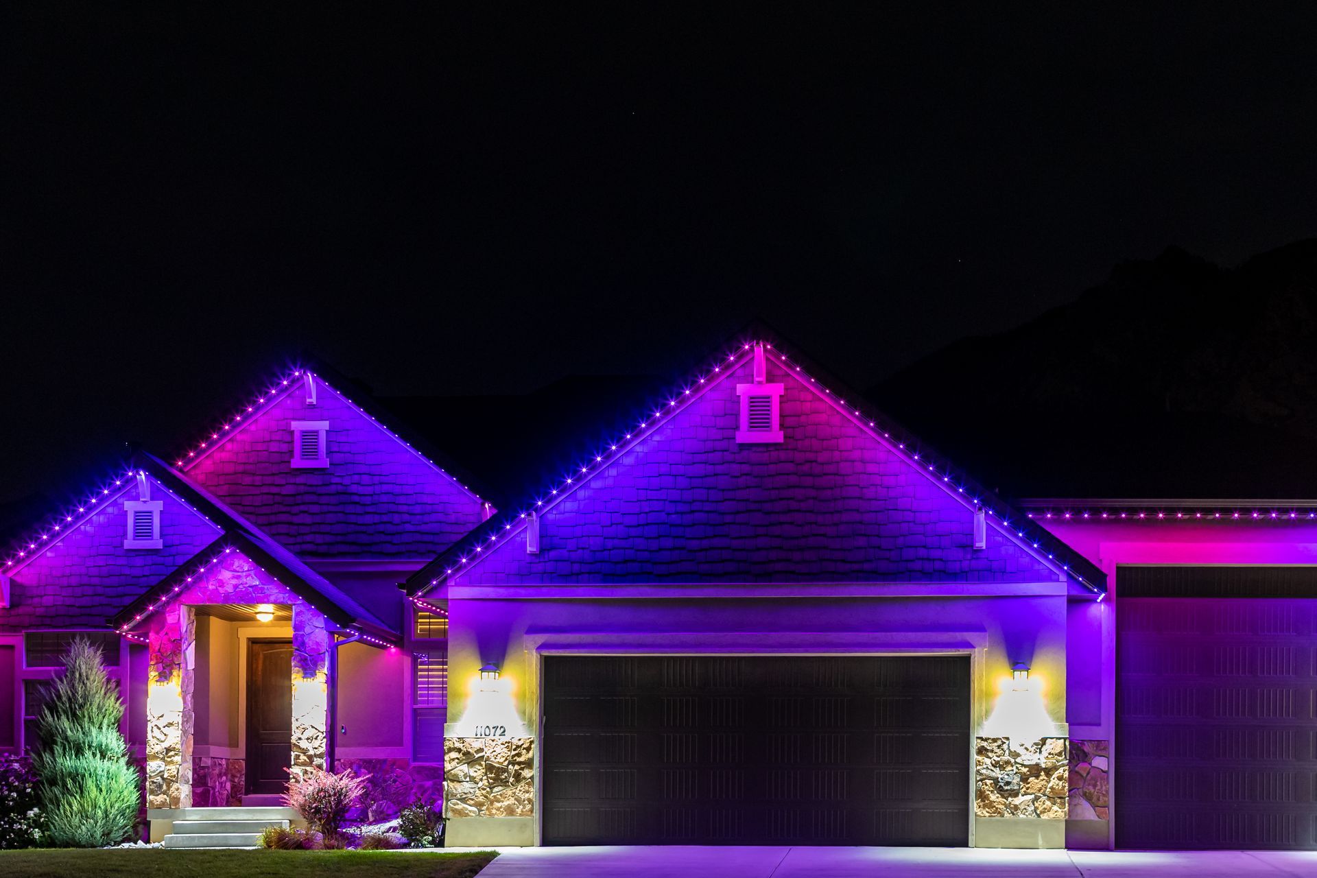 A house with purple lights on it at night.