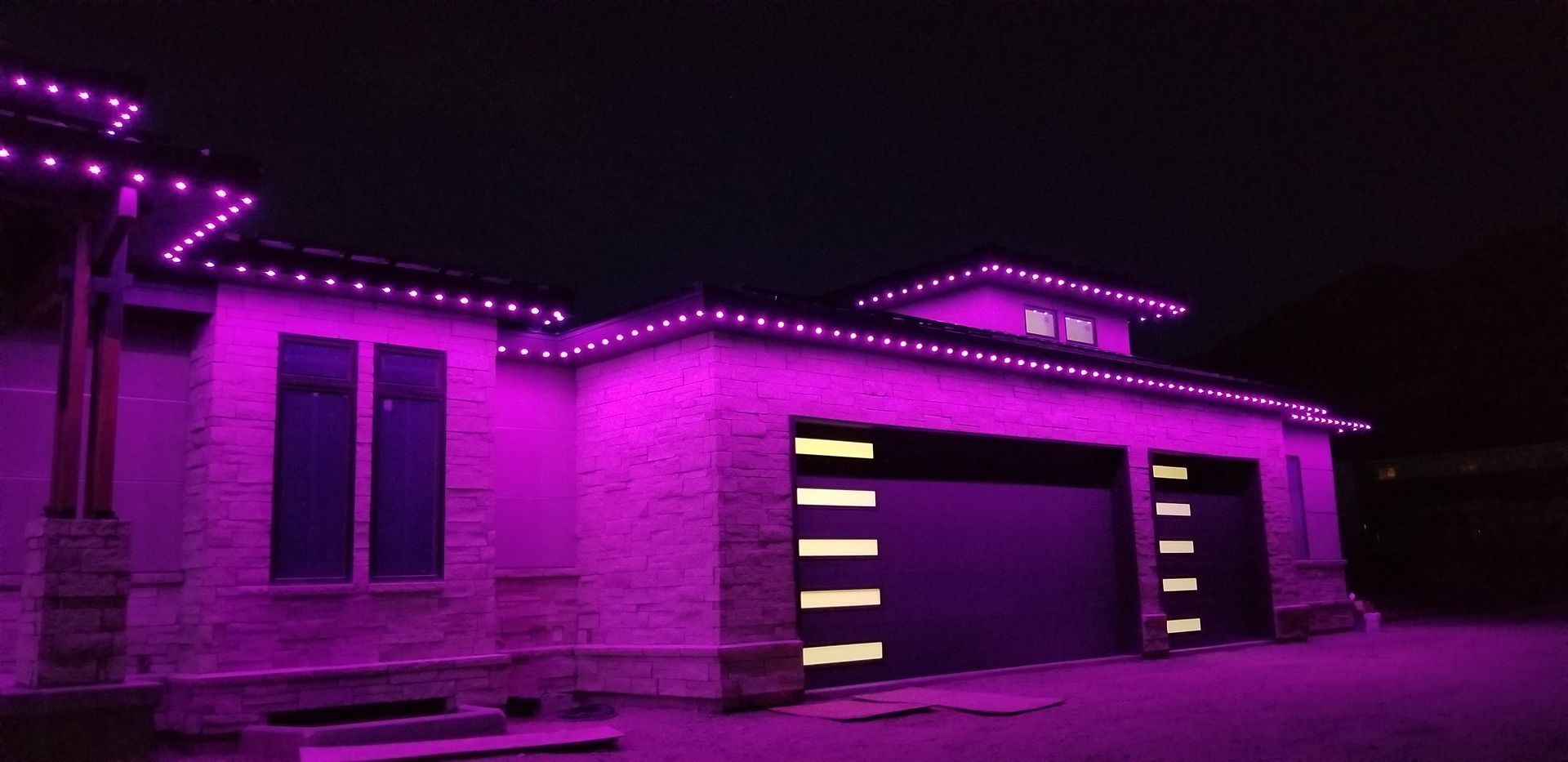 A house is lit up with purple lights at night.