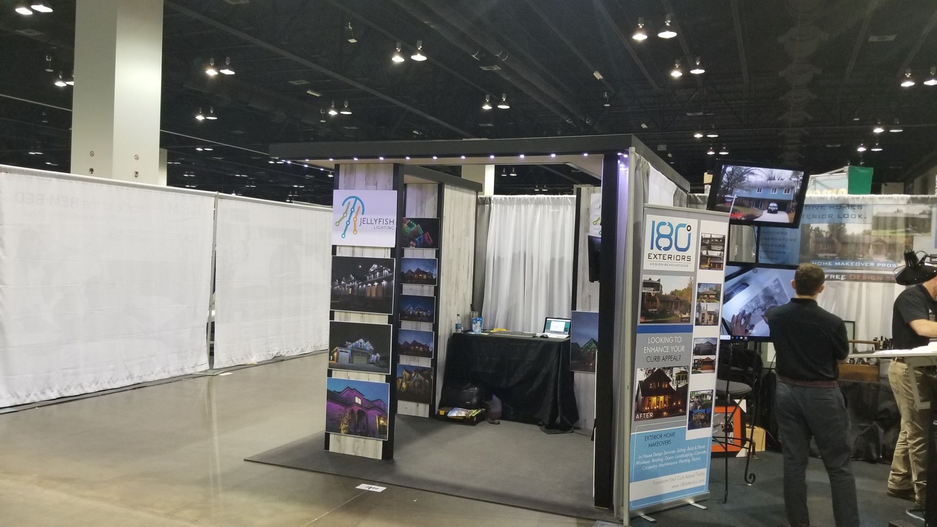 A man standing in front of a booth that says 180