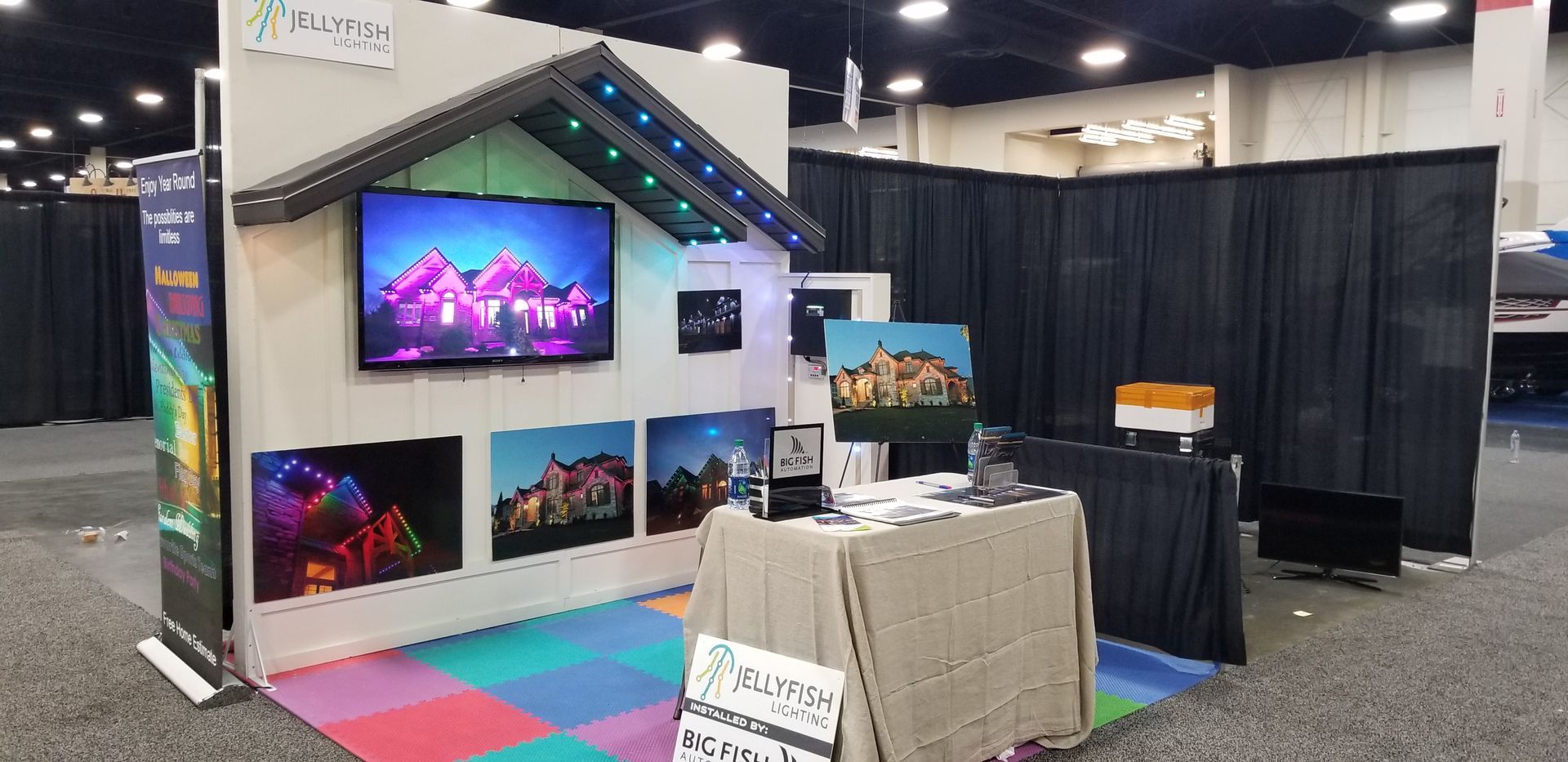 A booth with a table and a television on the wall.