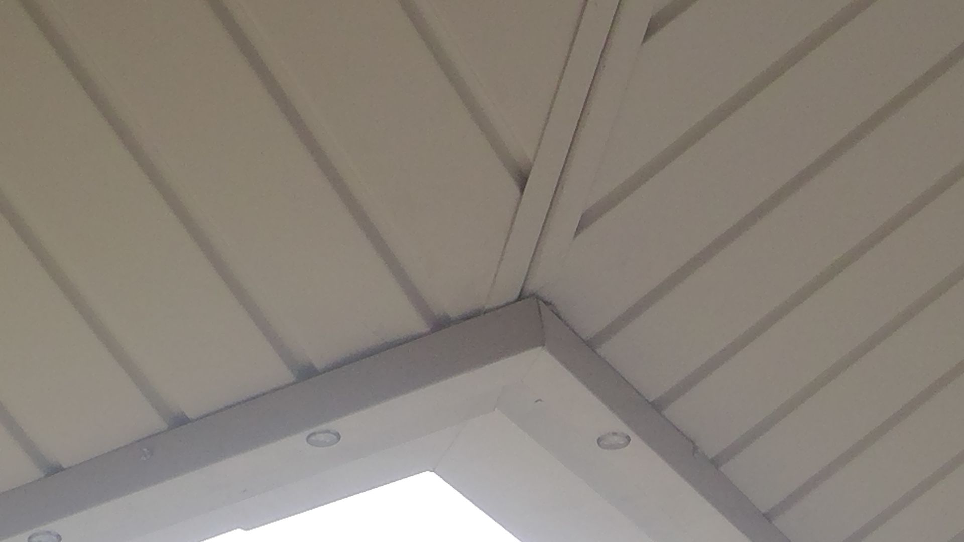 A white ceiling with a skylight in the corner