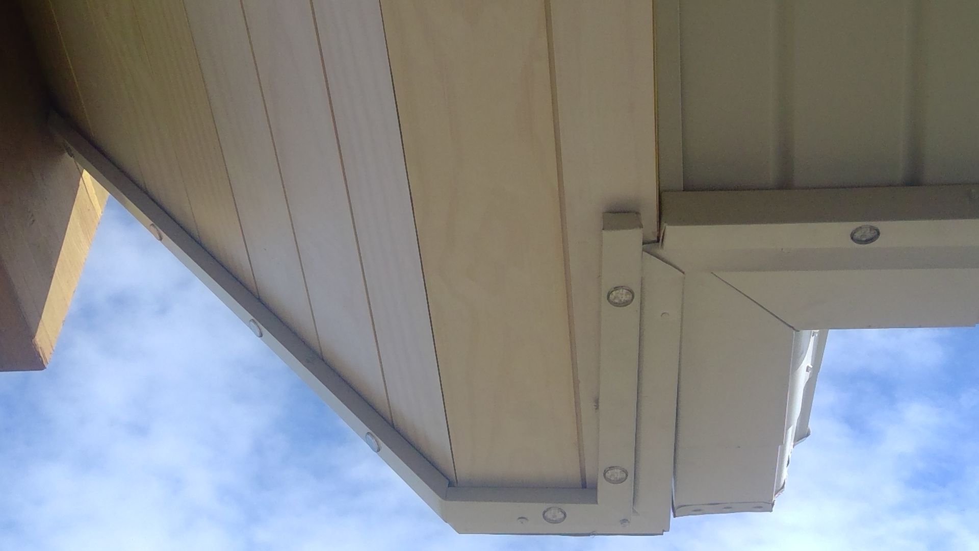 Looking up at the roof of a building with a blue sky in the background