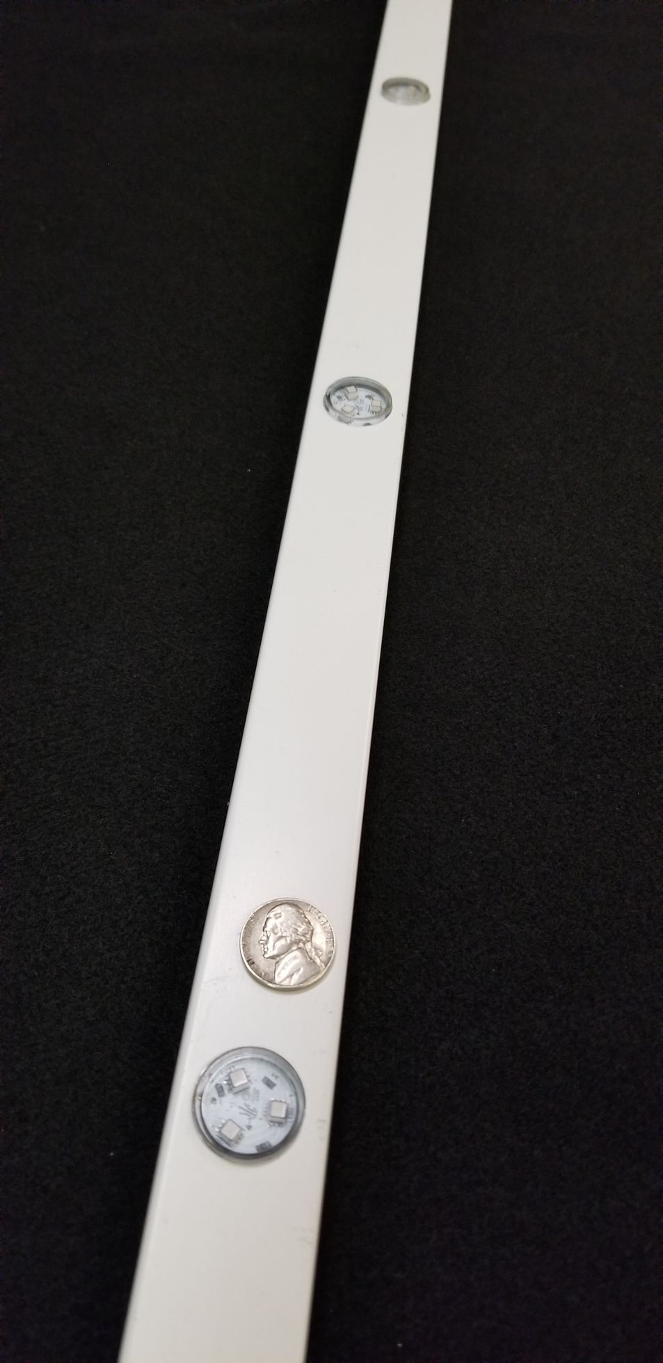 A white bar with buttons on it is sitting on a black surface.