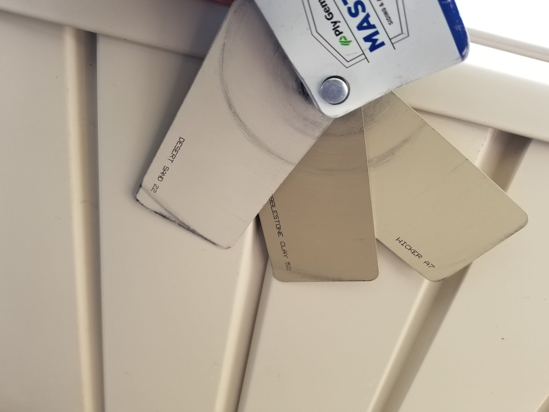 A bottle of mastic paint is sitting on a white surface