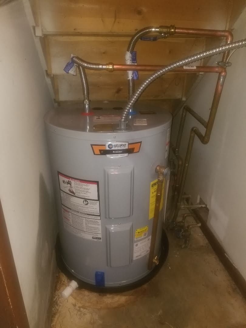 A water heater is sitting in a corner of a room.
