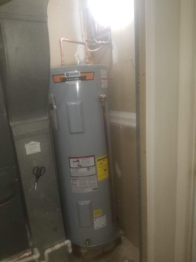 A water heater is sitting in a room next to a window.