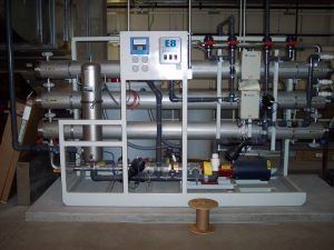 A machine in a room with a spool of wire in front of it.