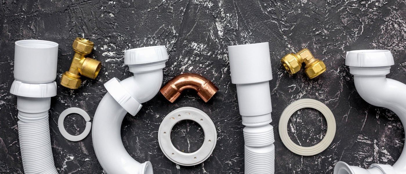 There are many different types of pipes and fittings on the table.