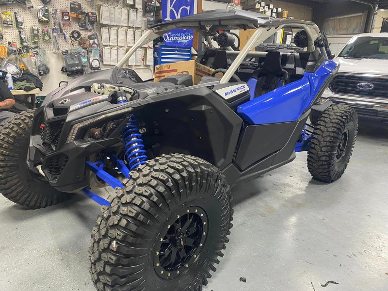 A blue and black atv is parked in a garage.