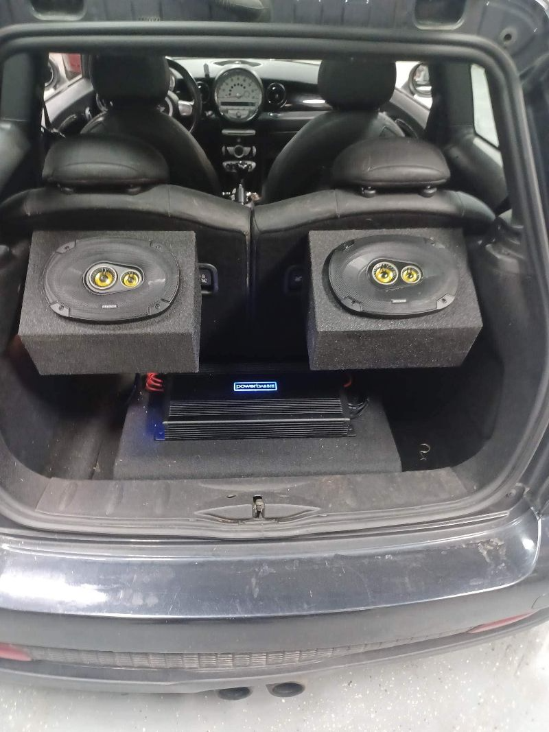 The trunk of a car with two speakers in it.