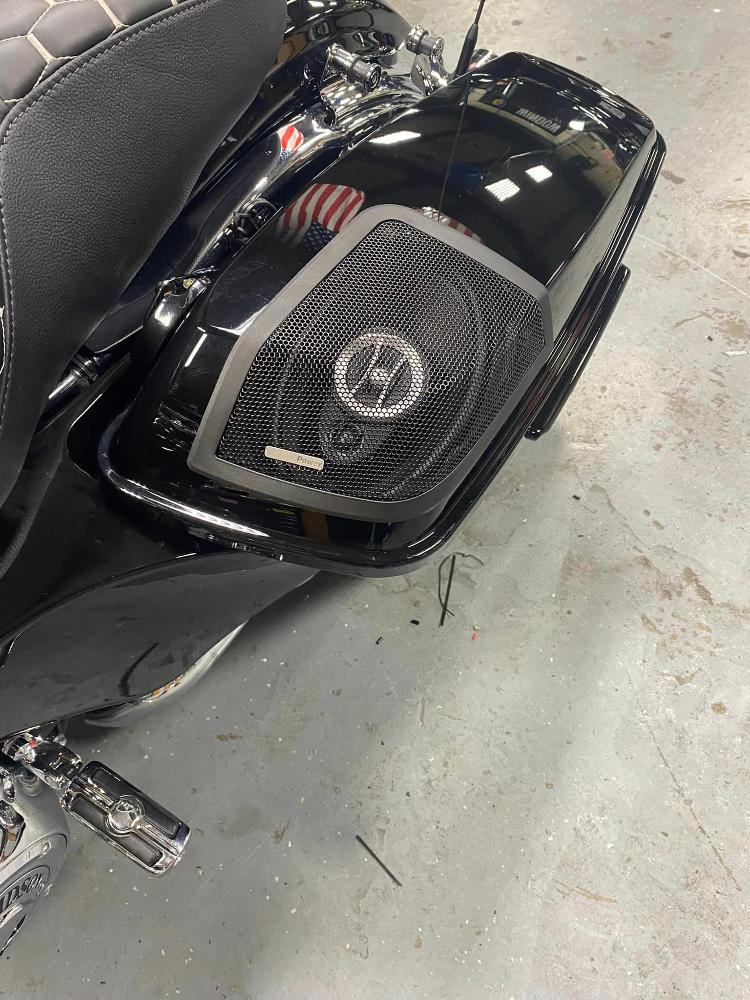 A close up of a motorcycle with speakers on the side.