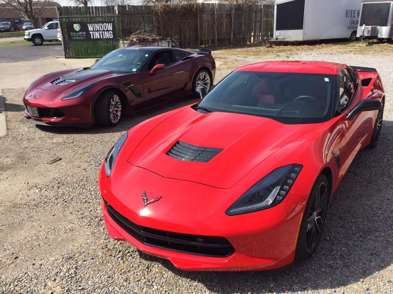 Two red sports cars are parked next to each other