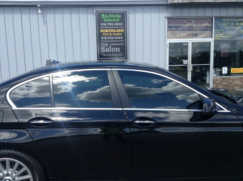 A black car is parked in front of a building.