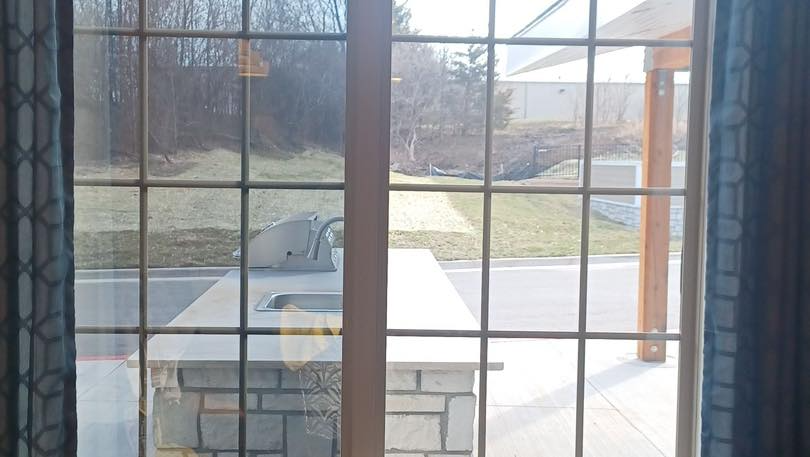 A window with a view of a kitchen and a patio.