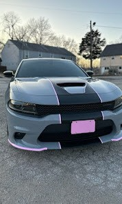 A gray dodge charger is parked in a parking lot.