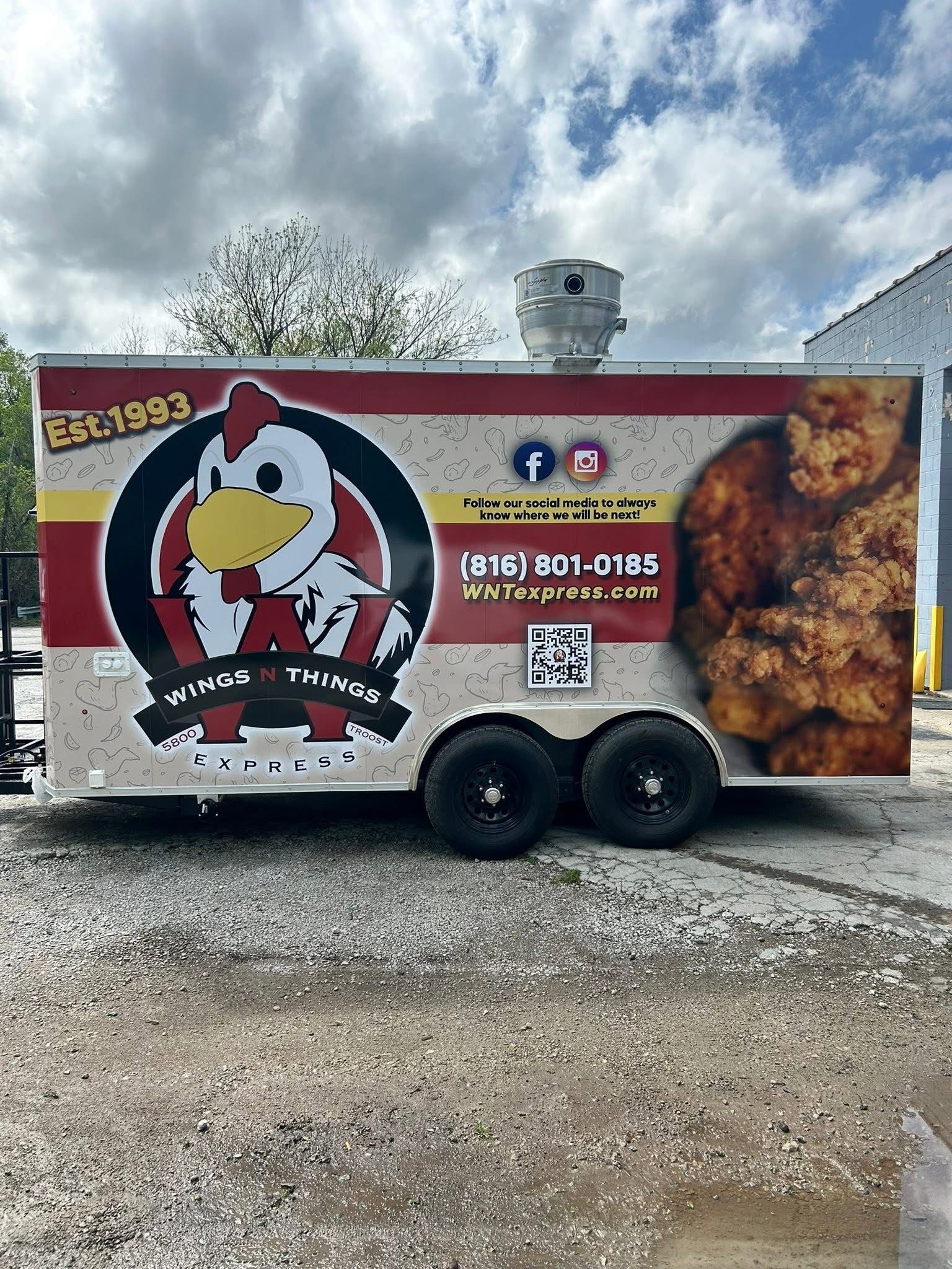 A food trailer with a logo of a cartoon chicken, red and cream stripes, and a large photo of fried chicken.