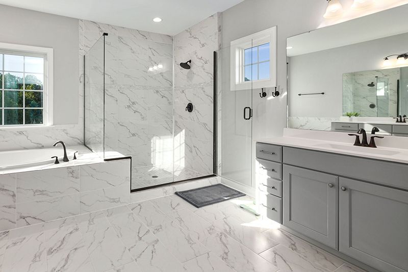 A bathroom with two sinks , a tub , and a walk in shower.