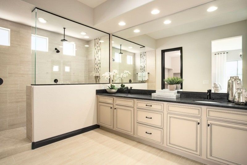A bathroom with two sinks and a walk in shower.