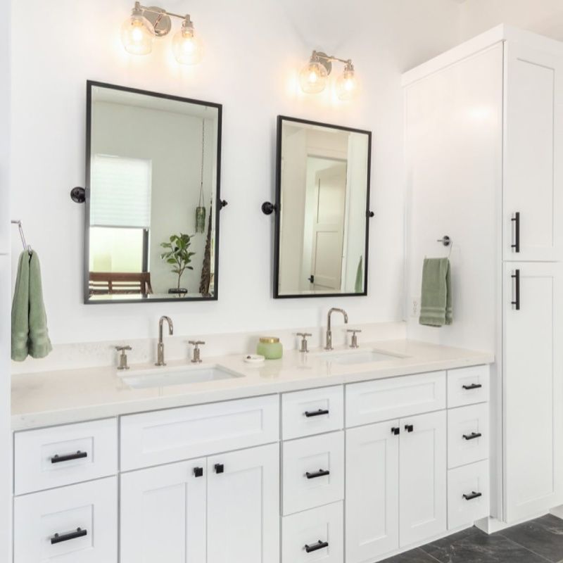A bathroom with two sinks and two mirrors