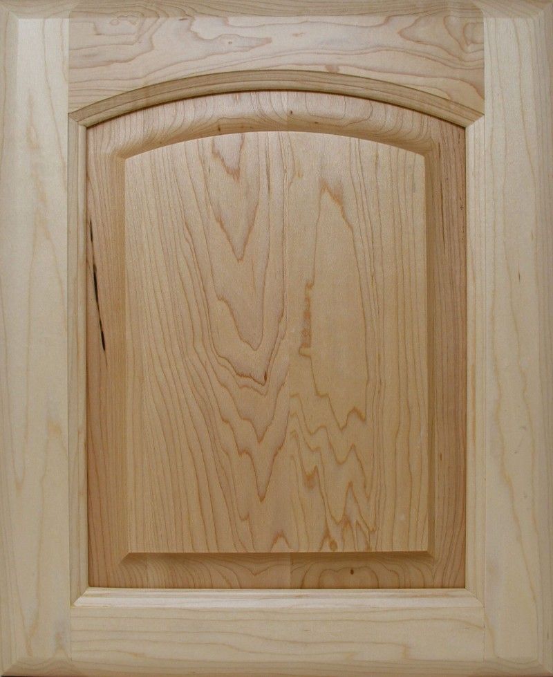 A close up of a wooden cabinet door with a curved arch.